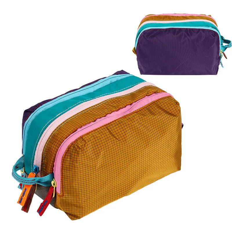 A multi-compartment travel toiletry organizer bag featuring striped fabric in shades of teal, pink, purple, and yellow.