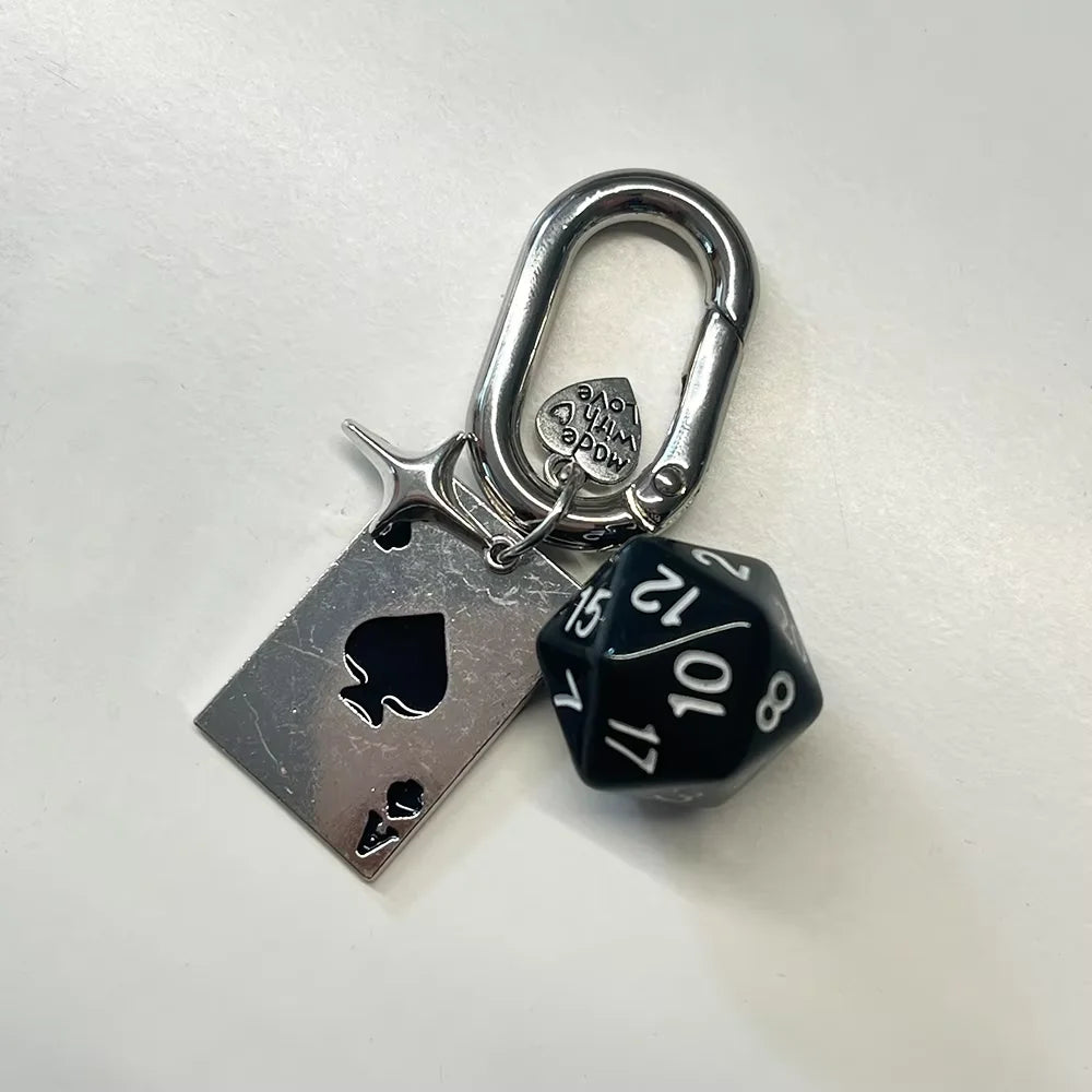 A silver keychain set featuring a padlock and a black and white die.