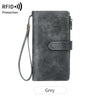 A grey leather trifold clutch wallet with a protective RFID shield and attached lanyard.