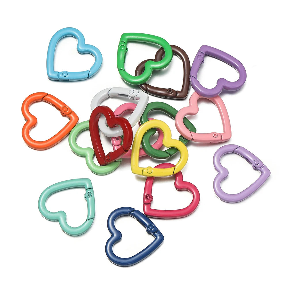 A collection of heart-shaped metal spring clasps in various colors including blue, green, orange, pink, and purple.