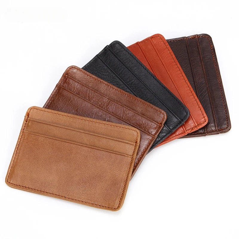 A stack of genuine leather card holders in brown, black, and orange shades.