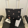 Black embroidered makeup pouch with a zipper displayed on a dark surface.