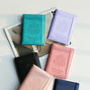 A collection of various colored RFID blocking PU leather passport holders displayed on a white background.