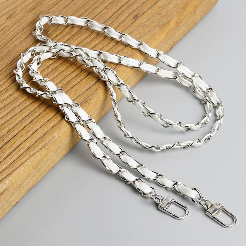 Silver leather crossbody purse chain strap laid on a wooden surface