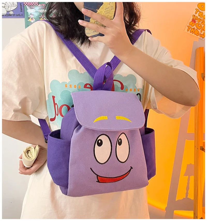 A purple Dora The Explorer cartoon flannel backpack worn by a person.