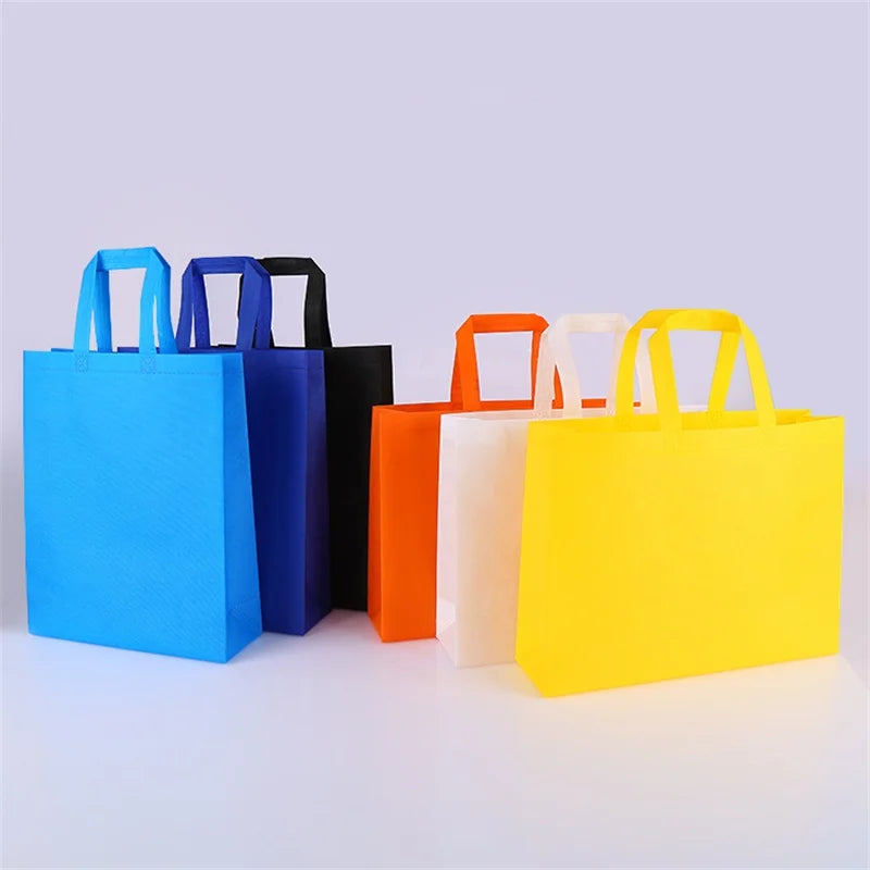 Eine Sammlung von zehn farbenfrohen nichtgewebten Einkaufstaschen in blau, lila, schwarz, orange, weiß und gelb.