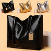 A black crocodile-textured leather tote bag with a gold metallic zipper detail shown in various angles.