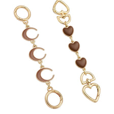 A set of gold-toned adjustable purse chains featuring heart and crescent moon charms.