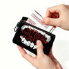 Eine Hand hält eine schwarze durchsichtbare Tasche mit weißer Schrift, die 'Will They Never Hurt' lautet