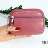 A hand holds a pink PU leather mini wallet with a silver keychain against a white background.