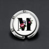 Silver foldable letter hanger hook with the letter M engraved and decorated with small flowers