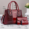 Bolso de cuero patentado con estampado de cocodrilo color granate, juego con bolsa y correa, mostrado en varias dimensiones.