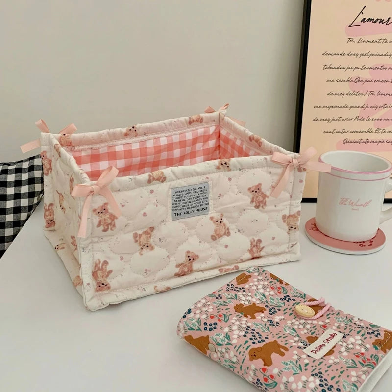 A quilted cotton storage basket with a lace flower design featuring pink and white patterns.