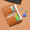 A brown PU leather small wallet holding various credit cards and coins on a tan background.