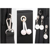 Black nylon crossbody phone bag featuring a zipper and adjustable strap with silver-tone earrings.