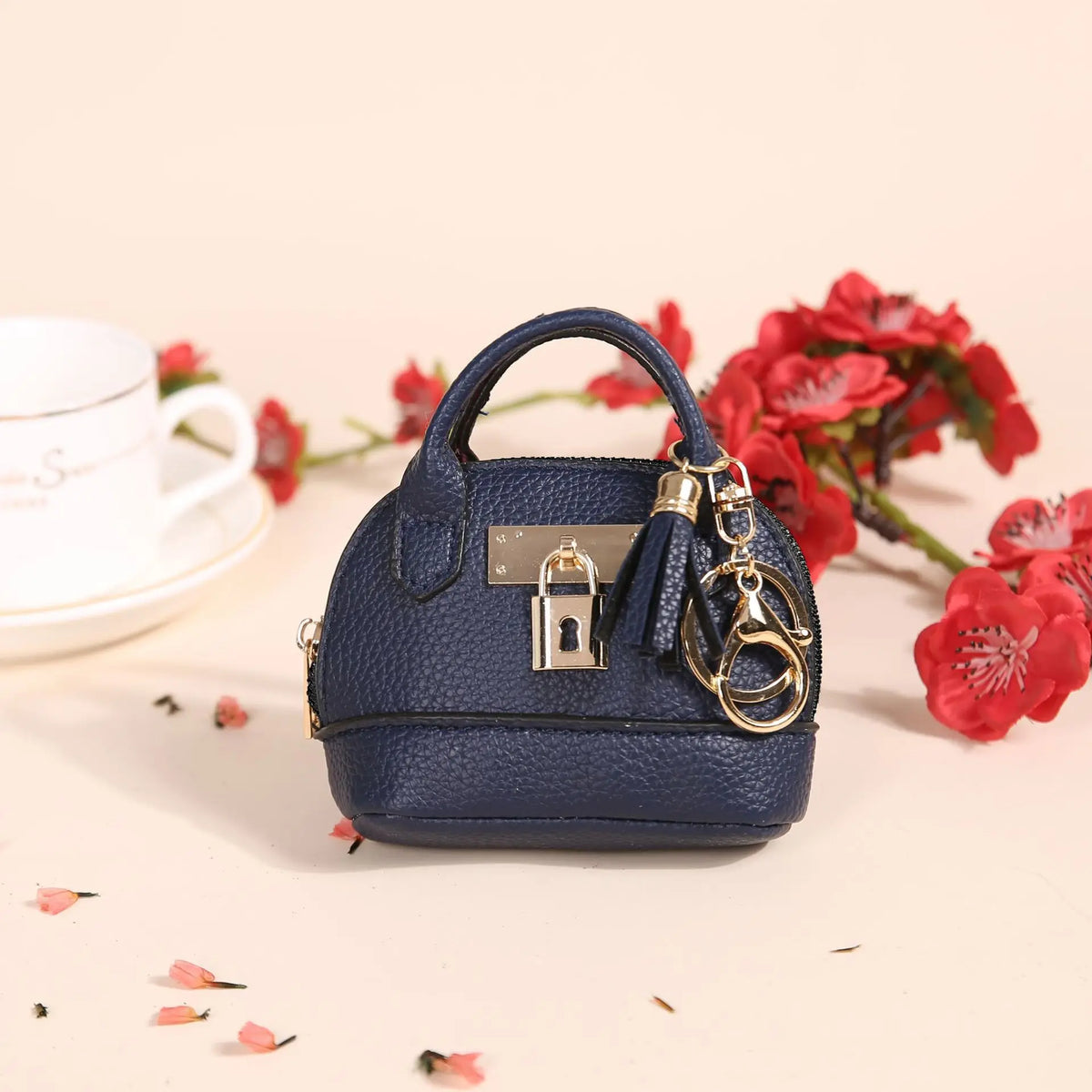 Portefeuille en plastique bleu marine de luxe avec une clé USB dorée, entouré de fleurs rouges.