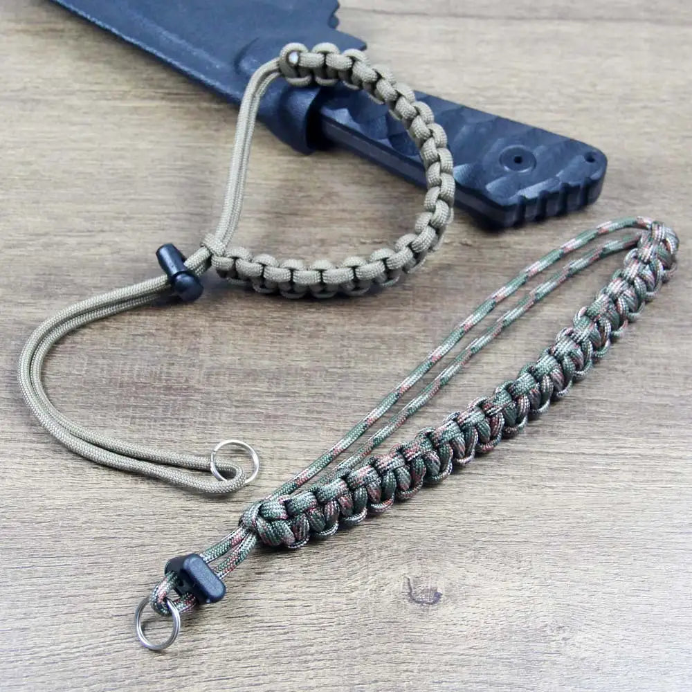 Handwoven paracord camera wrist strap with a dark gray cord and metal clasp resting on a wooden surface.