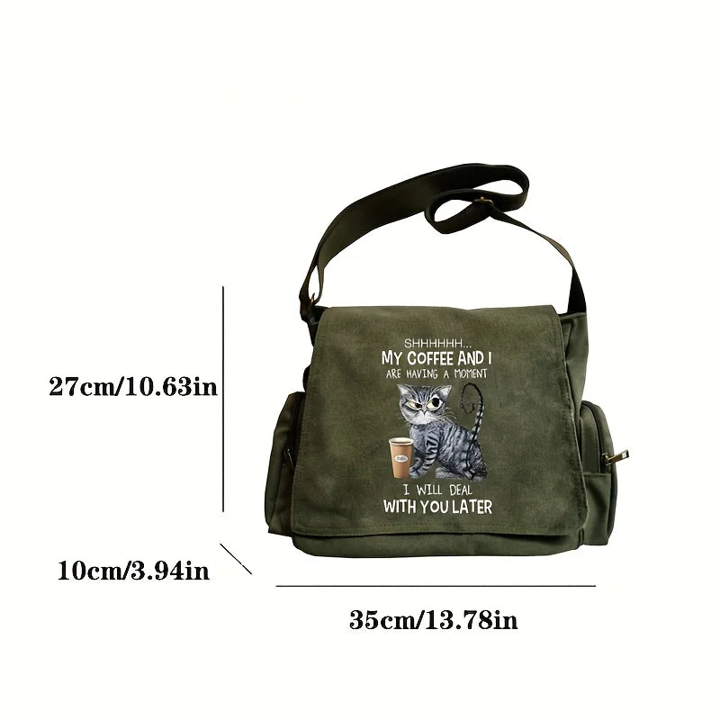 Olive green canvas messenger bag with a cat print design featuring text and an illustration of a cat.