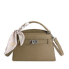 A beige PU leather crossbody clutch bag with a braided strap and silver hardware.