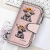 A pink zippered wallet featuring a cute puppy with flowers, placed next to a laptop keyboard.