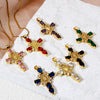 A collection of gold-plated cross and Virgin Mary charm pendants featuring various colored gemstones like ruby, emerald, and 