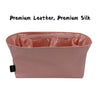 A pink leather and silk bag organizer insert with a flap closure.