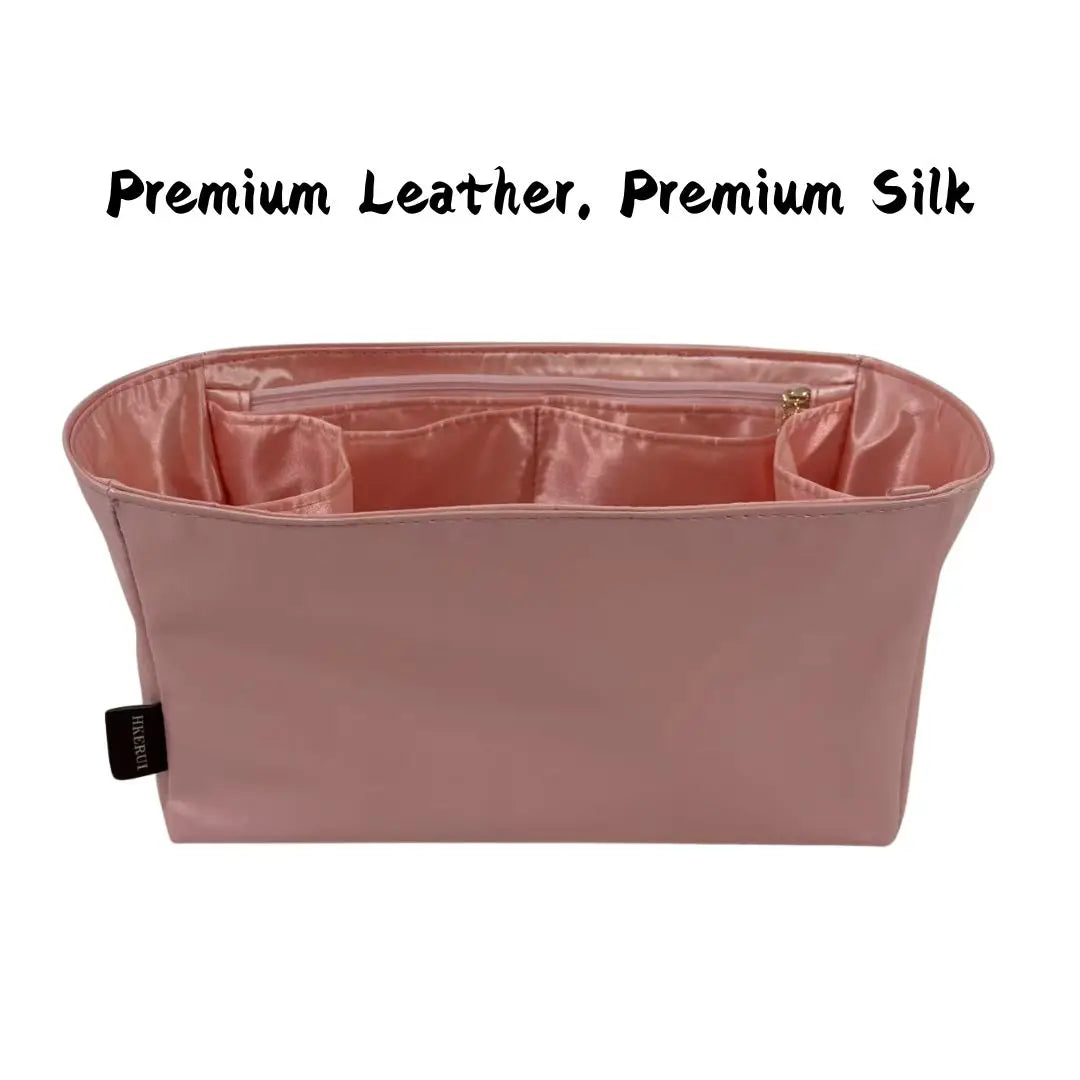 A pink leather and silk bag organizer insert with a flap closure.