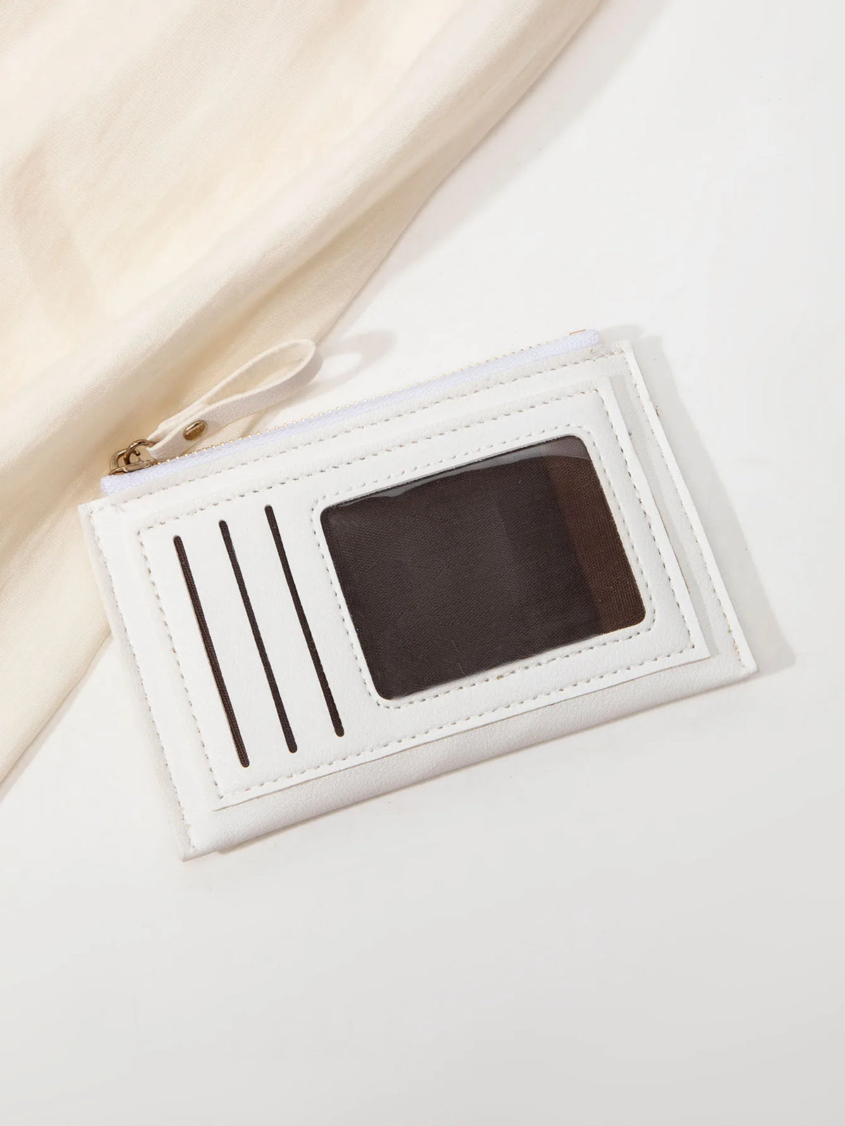 Portefeuille en cuir PU blanc minimaliste avec fente rectangulaire sombre et une fine ficelle blanche attachée.