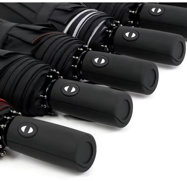 A close-up view of several black heavy-duty windproof automatic umbrellas lined up.