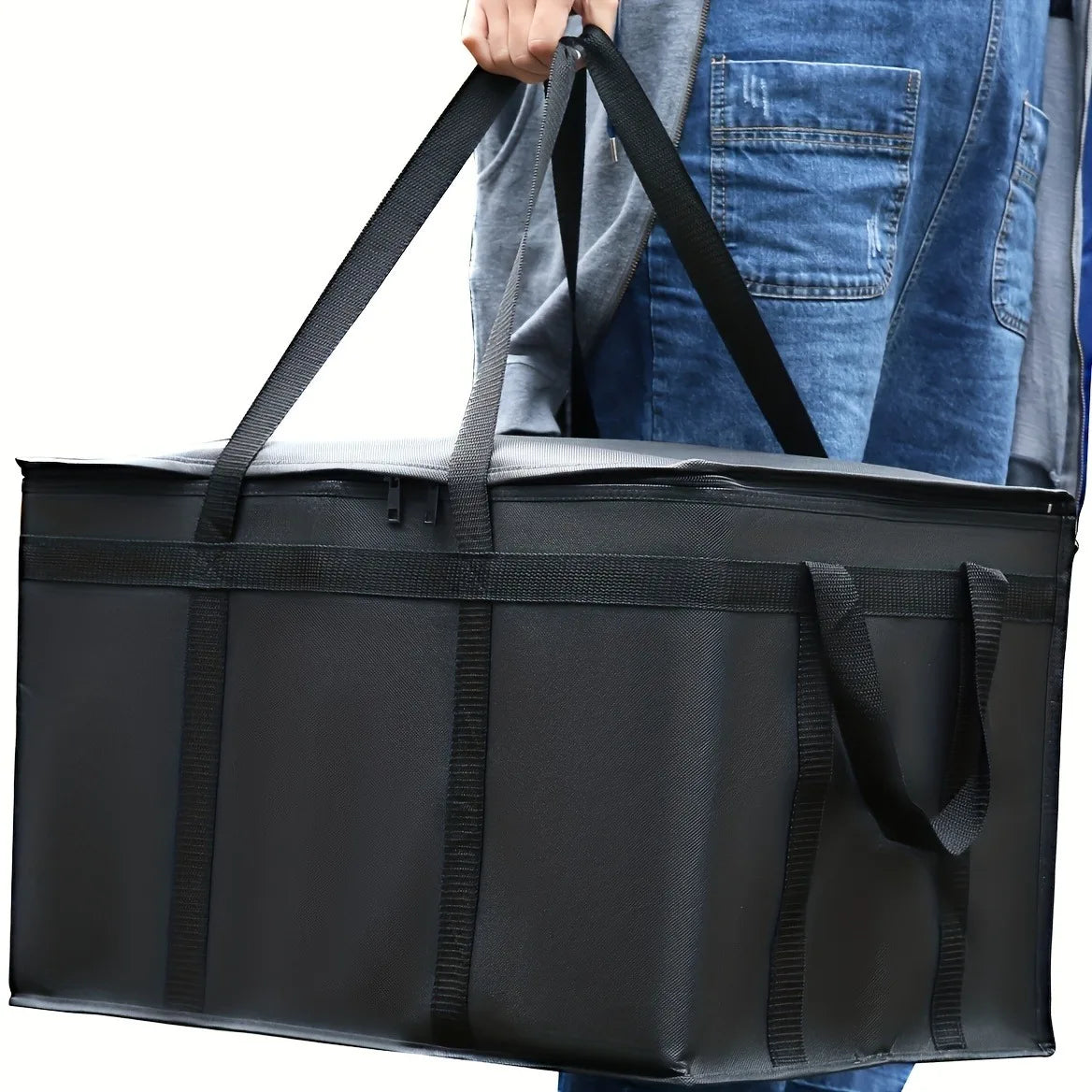 A black reusable insulated warming bag is being held by a person, shown from the side.