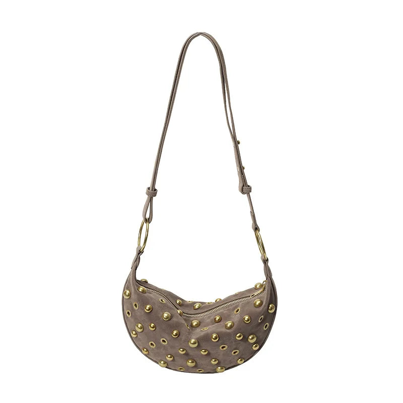 A brown faux suede hobo crossbody bag with gold rivet accents.