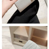 Eine Hand hält eine elegante silberne Ketten-Shoulderclutch mit strukturierter Oberfläche vor dunklem Hintergrund.