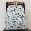 A light-colored backpack featuring a pattern of various bird and animal prints, displayed on a wooden chair.