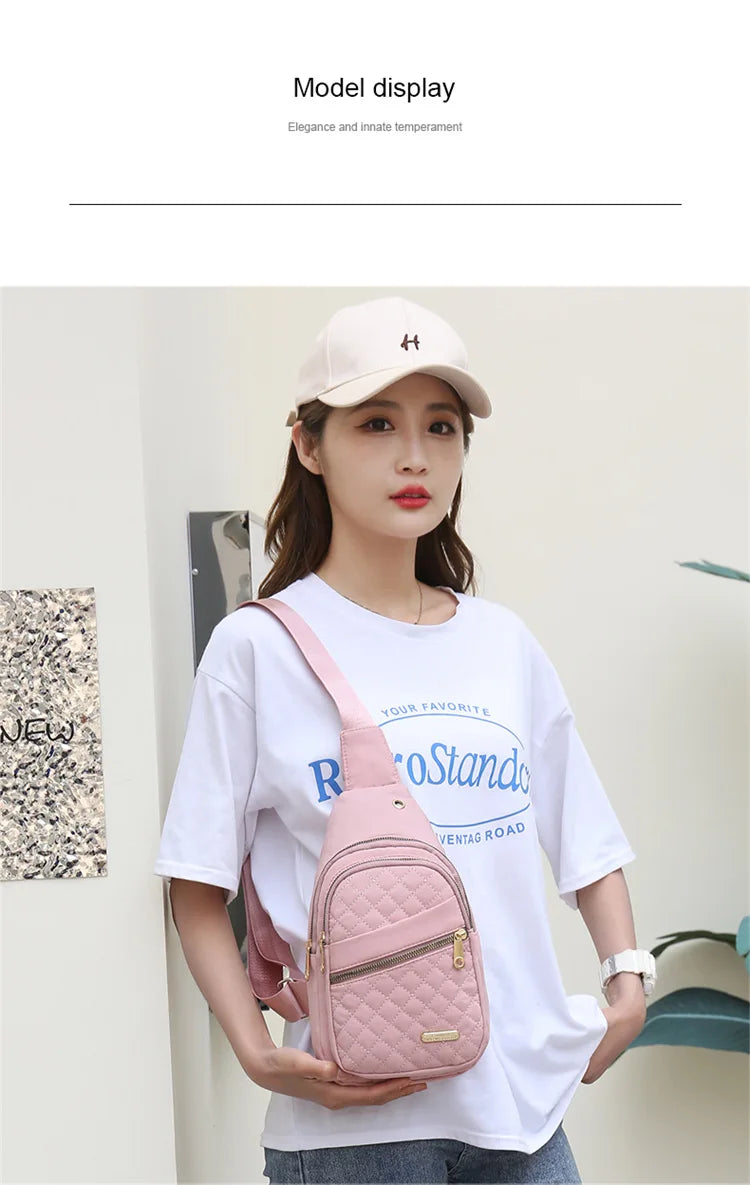 Eine Frau präsentiert eine rosa wasserdichte Crossbody-Tasche und eine beige Mütze vor hellem Hintergrund.