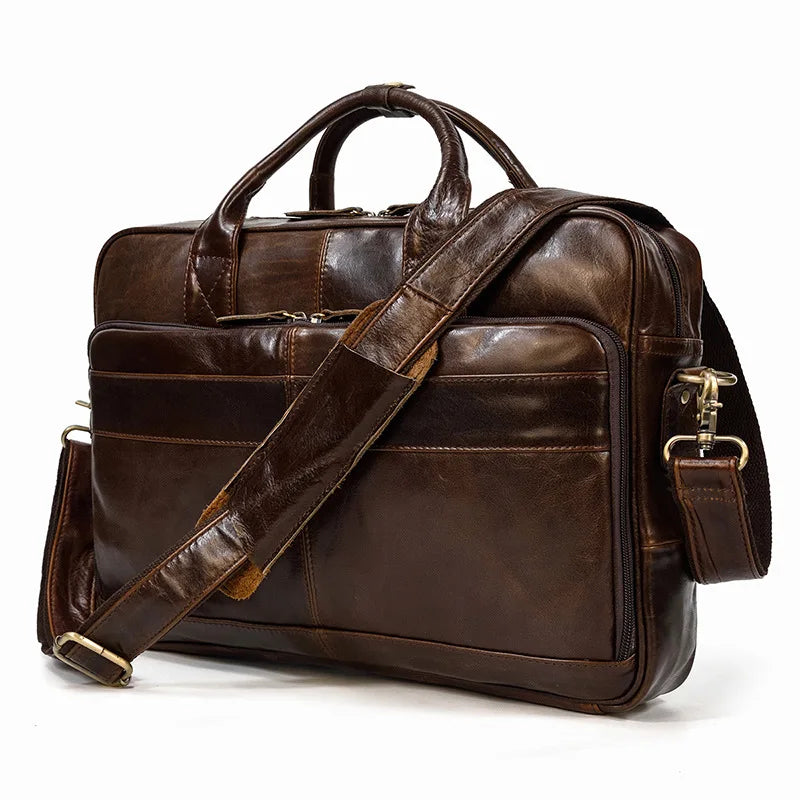 A dark brown vintage genuine leather briefcase with a leather strap is shown against a white background.