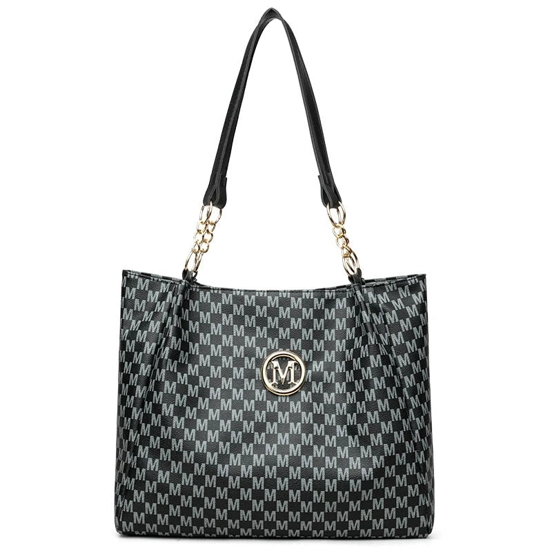 Black geometric monogram tote bag with gold hardware and black leather strap