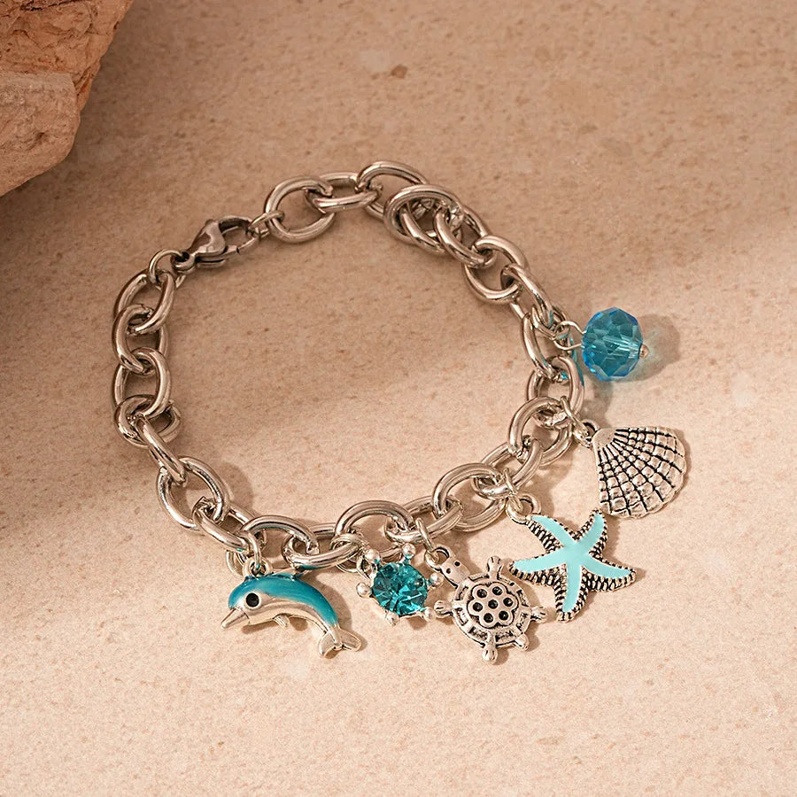 Silver chain bracelet featuring an ocean pearl charm with starfish and shell accents