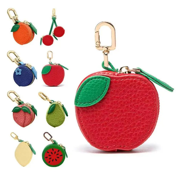 Collection de porte-clés et de pièces de monnaie fruitées rouges et vertes, avec des pommes, des oranges et d'autres fruits.