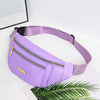 A purple lightweight nylon crossbody fanny pack with a gold zipper and purple strap is displayed on a white surface next to a