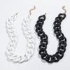 A pair of necklaces, one white and one black, featuring a chunky chain design.