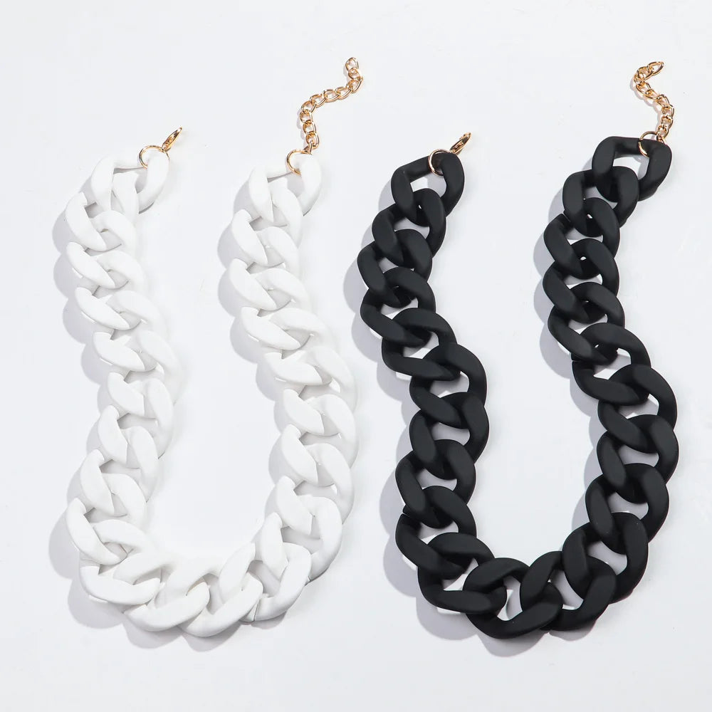 A pair of necklaces, one white and one black, featuring a chunky chain design.