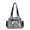 A black leopard print tote bag with an adjustable strap.