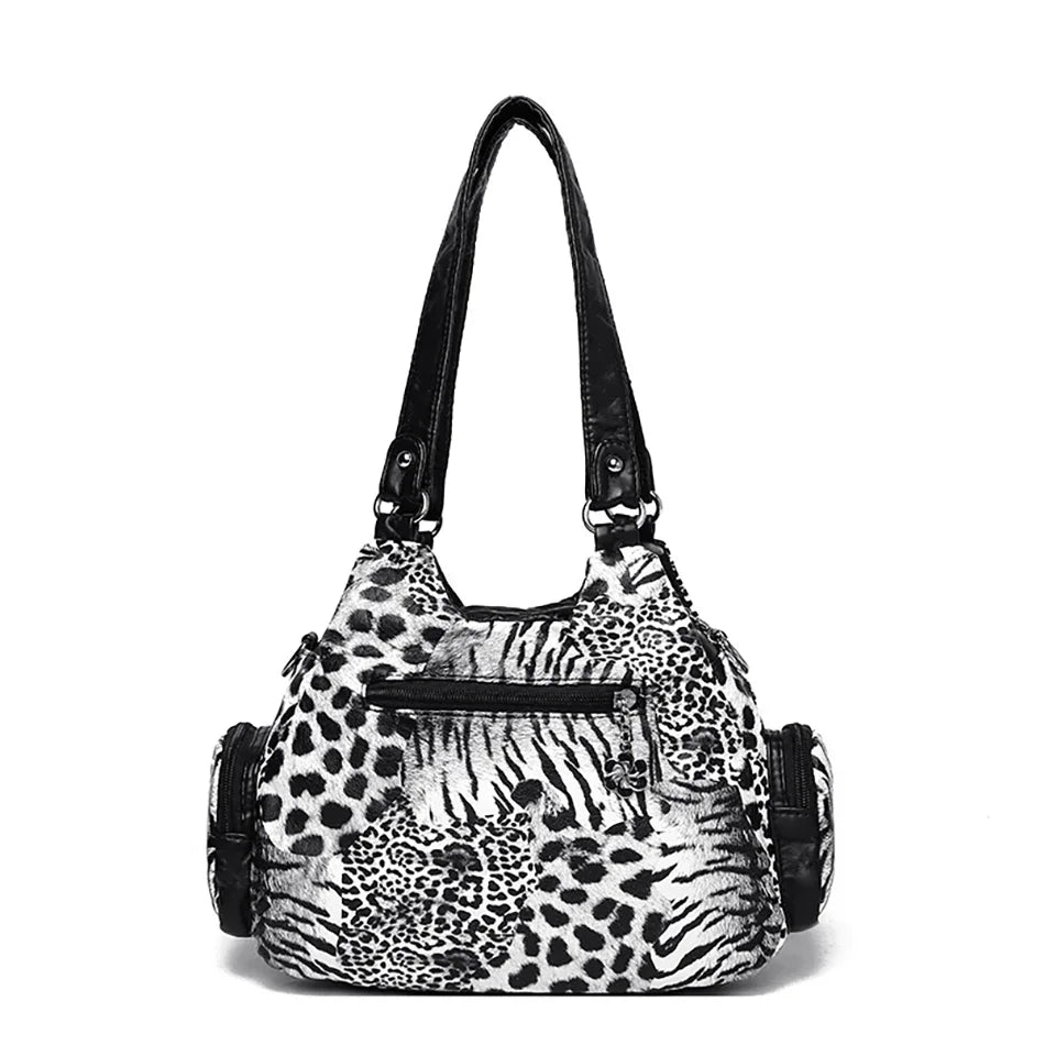 A black leopard print tote bag with an adjustable strap.