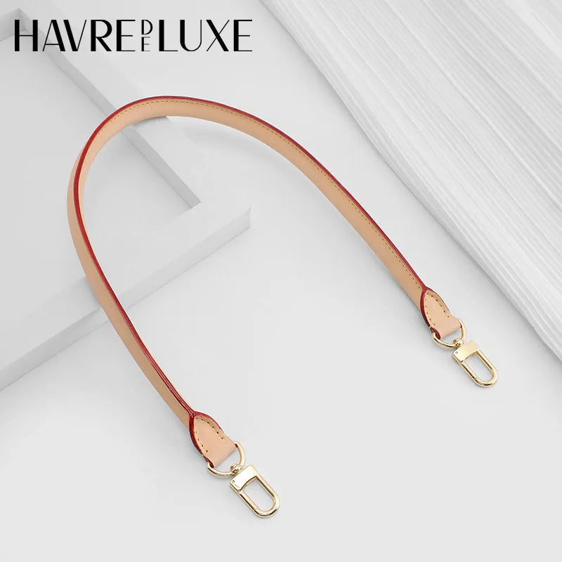 A tan leather strap with gold hardware is shown against a white background.