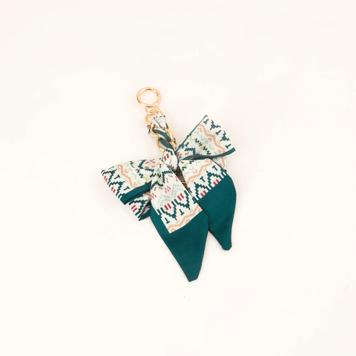 Lazo de cinta de seda color verde azulado atado en un nudo decorativo con anillo de llavero dorado.