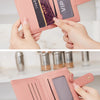 A pink PU leather bifold wallet with a zipper closure is shown being held by hands.