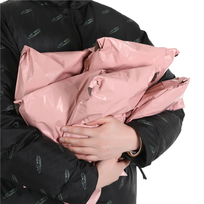 Bolsas de almacenamiento rosadas autoadhesivas sostenidas por una persona con una chaqueta negra