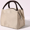 A beige and white striped insulated lunch tote bag with a dark brown adjustable shoulder strap.