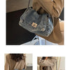 A close-up of a vintage-inspired denim tote bag with a chain strap carried by a person wearing a tan blazer.