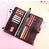 A brown genuine leather vintage clutch wallet is shown open, displaying various colored cards and documents on a light pink b
